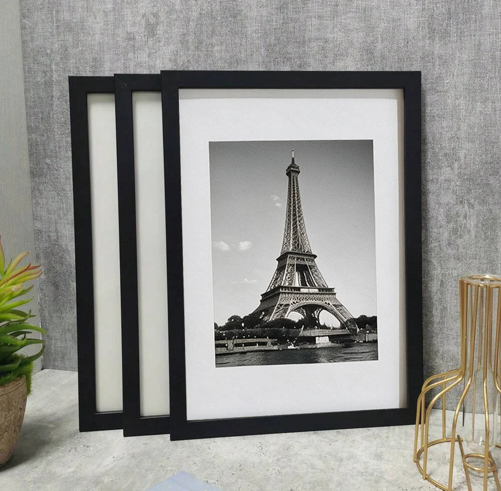 A set of three black wooden photo frames displaying a black and white image of the Eiffel Tower.