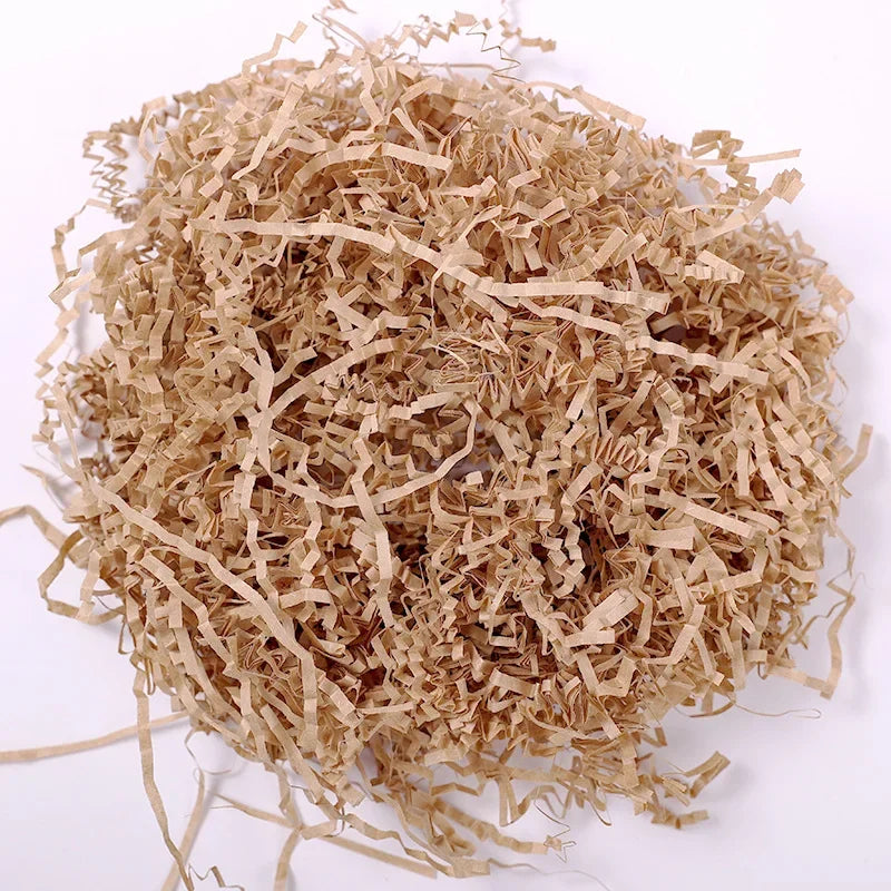A pile of light brown crinkle cut paper shred filler material.
