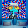 A vibrant tapestry wall art featuring a psychedelic blue character against a swirling rainbow background.