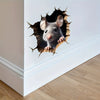A realistic gray mouse head is emerging from a dark, jagged hole in a white wall.