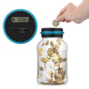 A hand is dropping a gold coin into a clear glass piggy bank next to a digital counter displaying $333.66.