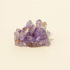 A cluster of purple amethyst crystals used as a Reiki amulet or decorative figurine.