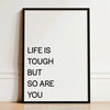 A framed canvas print with the text Life is tough but so are you written in black on a white background.