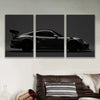 Three panels of black sports car silhouette canvas wall art displayed on a white wall.