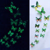 A collection of twelve colorful, luminous butterfly wall stickers on a white background.