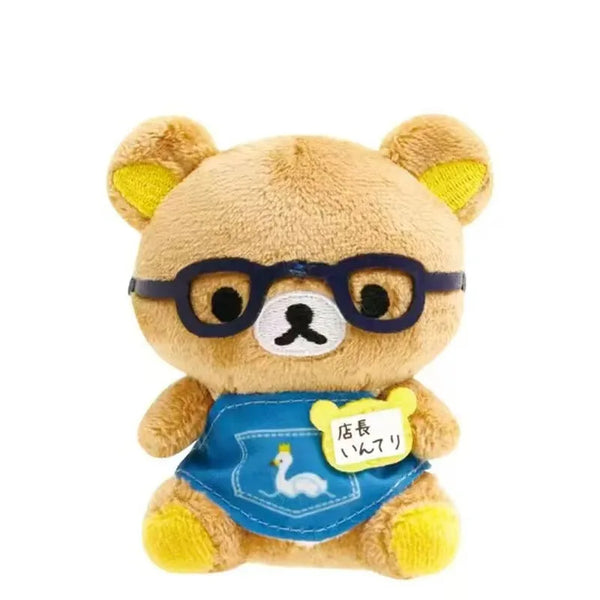 A cute brown bear plush toy with glasses and a blue apron.