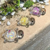 Colección de estatuas de tortugas marinas de vidrio transparente con purpurina de colores, sobre una superficie clara