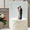 Elegant bride and groom cake topper featuring a couple embracing against a white floral background