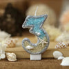 Glitter number cake topper shaped like the number 3 with a starfish design