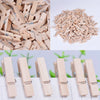 A pile of natural wooden mini clothespins for crafts and decor, shown in various angles.