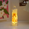 A glowing yellow flameless LED religious prayer candle with a glass holder and a decorative top.
