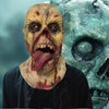 A close-up of a grotesque, pale face with red markings and a long tongue emerging from a latex mask.