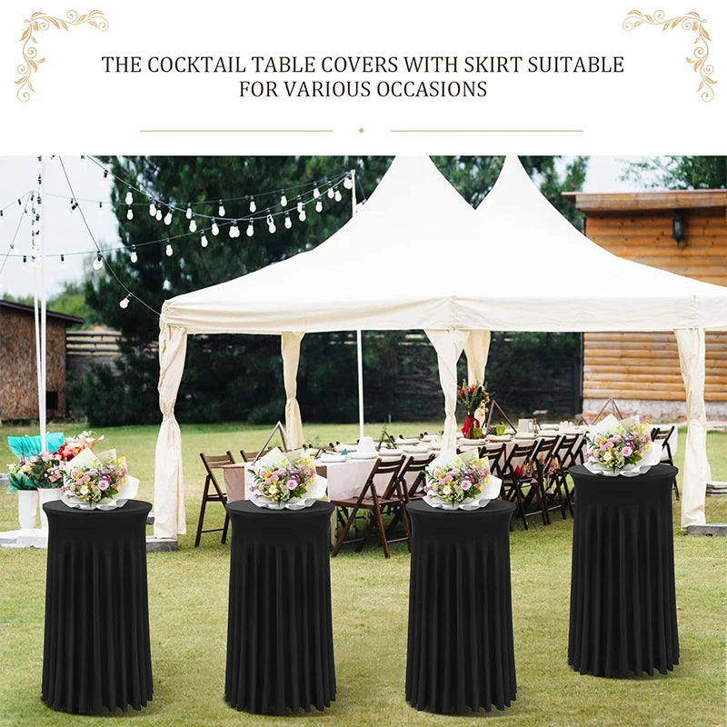 White tent setup for an outdoor event featuring black cocktail tables with skirt covers.