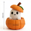 A small orange pumpkin with a green leaf and a white face is sitting in an orange hollow.