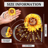 A hand holds a round, clear sunflower-shaped plaque with inspirational Bible verses engraved on it.