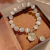 A bracelet made of small, round, translucent white natural stones, displayed in a velvet box.