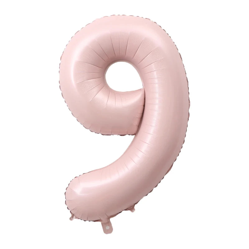 A large pink foil number balloon shaped like the number 9.