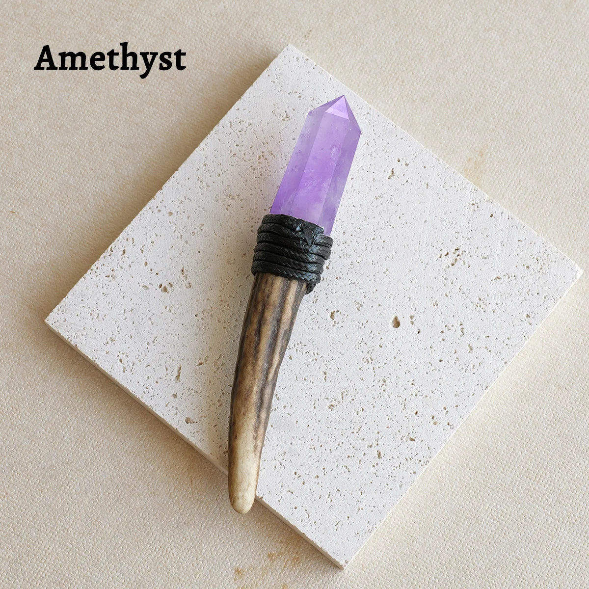 A purple amethyst crystal point set in a wooden scepter wand displayed on a white square card.