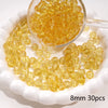 A small glass bowl filled with round, translucent yellow spacer beads for jewelry making.