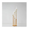 Elegant gold metal candle holders with slender white candles displayed against a white background.