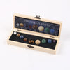 A wooden box containing a set of nine natural crystal gemstone spheres displayed in an open lid.