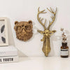 A brass deer head storage hook wall decor featuring antlers and glasses mounted on a white wall.