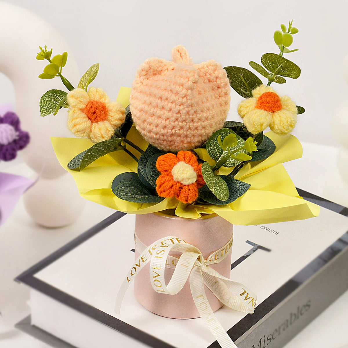 A handmade crochet tulip bouquet featuring peach and orange flowers in a yellow paper wrap.