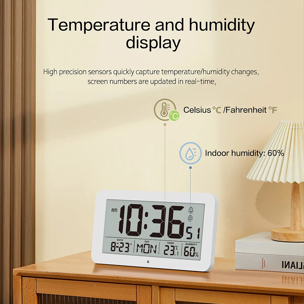 A white digital clock displaying 10:36 and showing temperature, humidity, and time information on a wooden surface.