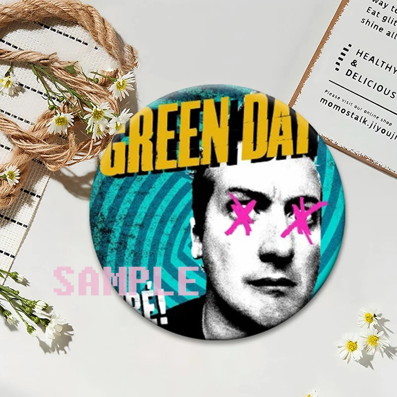 A circular button pin featuring a black and white portrait of a man with bright pink accents, set against a teal background.