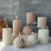A collection of white Nordic bubble scented soy candles in various sizes and textures displayed on a light surface.