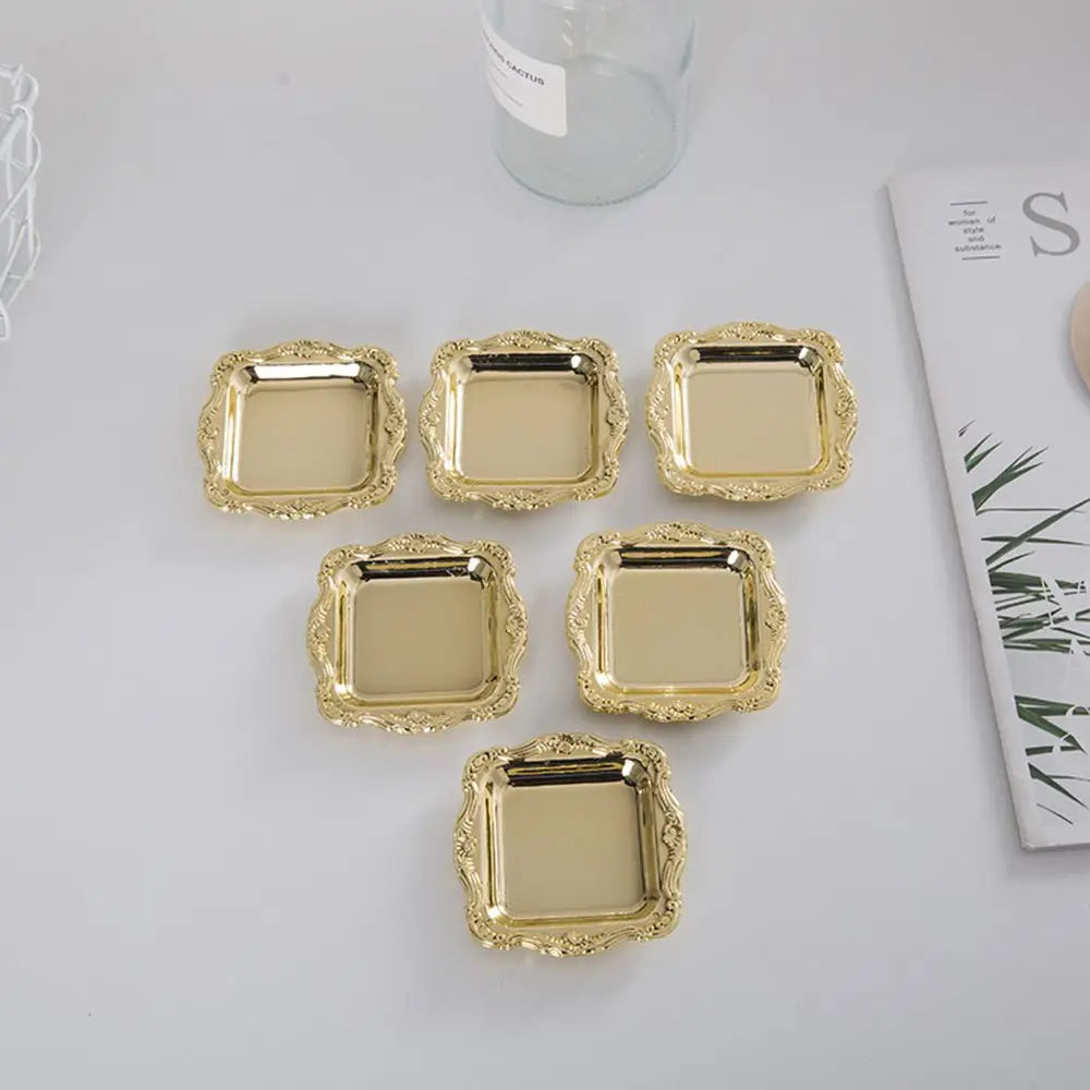 A collection of ten small, gold-colored mirror-finish trays for jewelry, snacks, or decor.