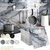 Silver kitchen utensils hanging on a marble-patterned backsplash with a decorative marble slab.