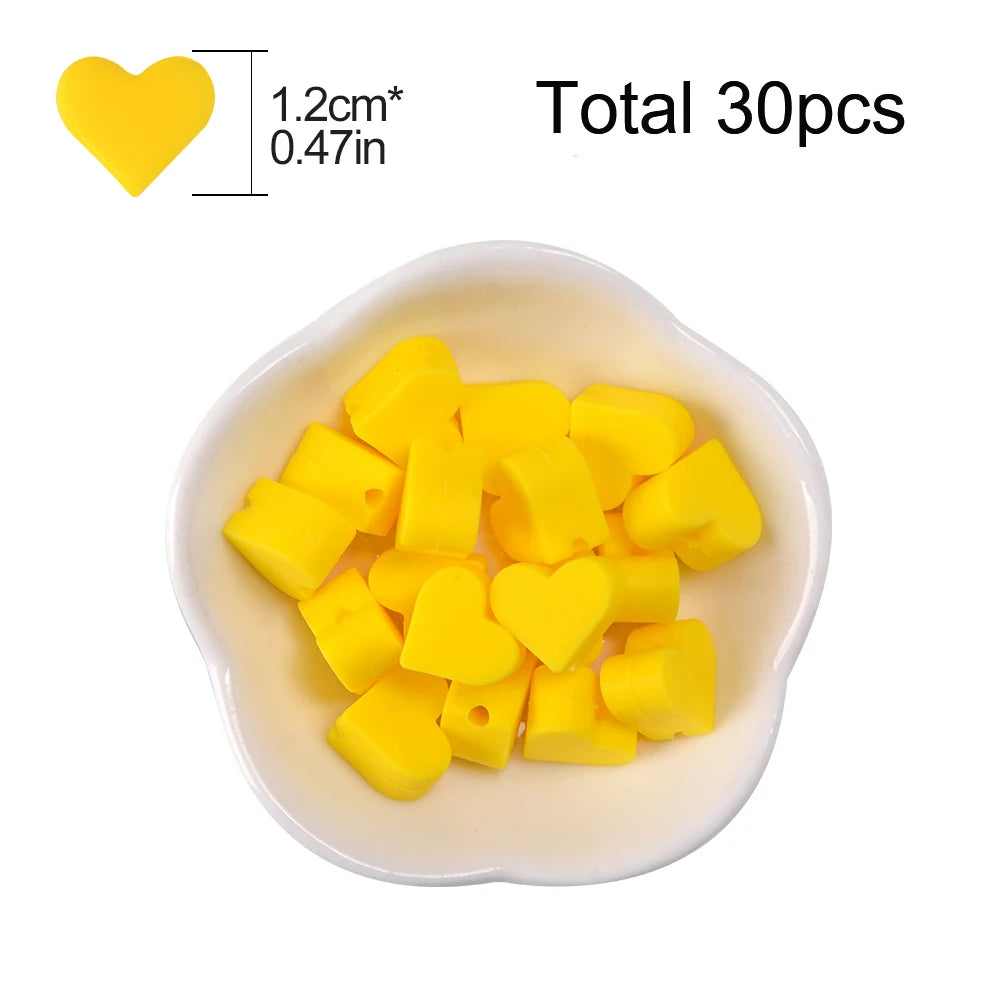A bowl filled with 30 yellow silicone heart beads for DIY jewelry making