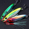 A set of three metal jig fishing lures with hooks and feather blades displayed against a black background.