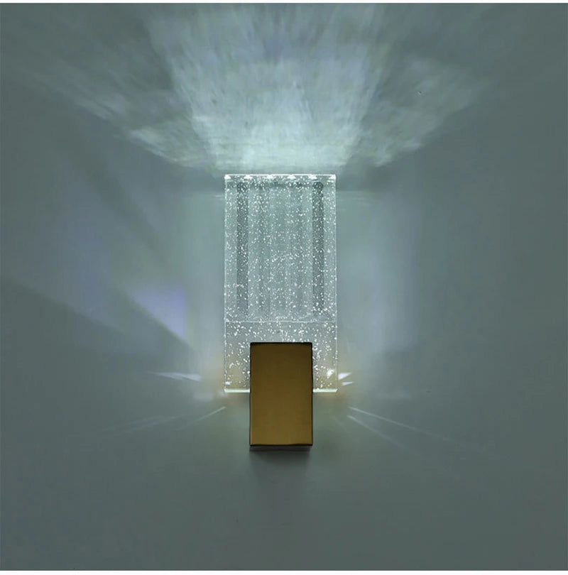 Modern bubble crystal LED wall sconces illuminating a rectangular gold panel.