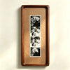 A wooden frame holds a vertical photo strip featuring several close-up portraits of couples.