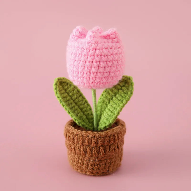 Handcrafted pink crochet tulip flower growing in a brown pot
