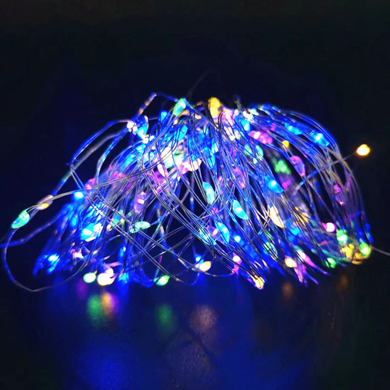 A bundle of blue and purple fairy string lights glowing brightly against a dark background.