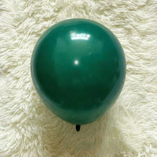 A single, glossy teal latex balloon resting on a white, fluffy surface.