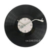 A black decorative vinyl record wall clock with a white face and hands.