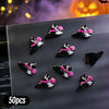 A variety pack of 50 black and pink Halloween themed resin nail charms displayed on a gray surface.