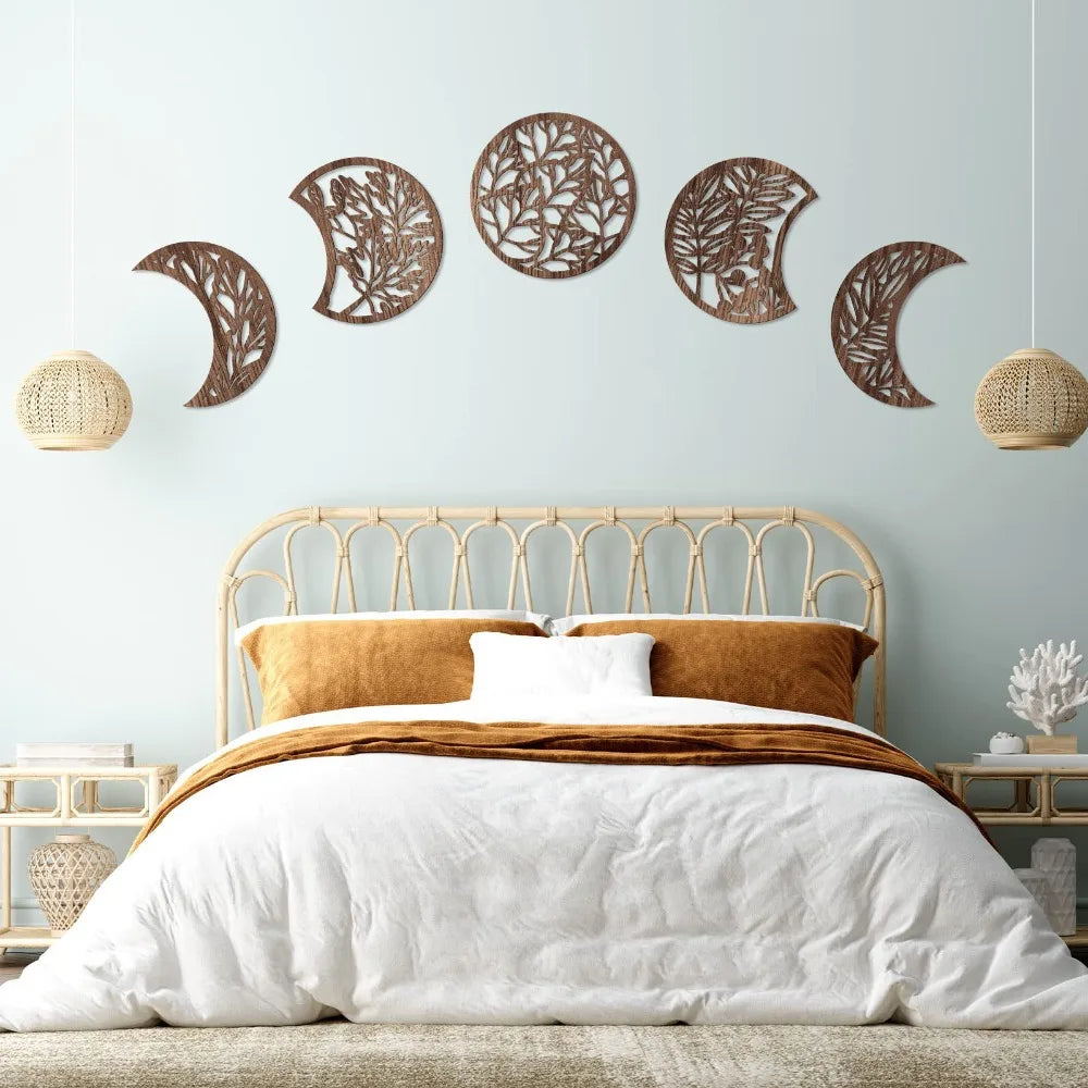 Nordic wooden moon phase wall art featuring various cut-out silhouettes on a light blue wall above a bed.