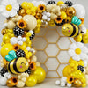 A vibrant balloon garland featuring yellow, gold, and white balloons with bee and flower accents.