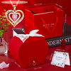 A pink heart pendant necklace is displayed next to a red rose gift box and a small glass bottle.