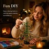 A woman is crafting a sparkling crystal bead Christmas tree kit indoors.