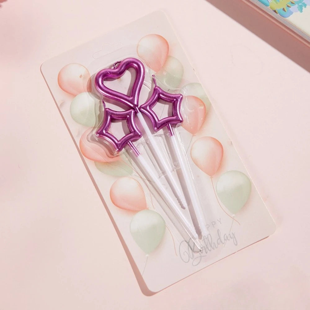 A set of gradient blue metallic birthday candles with purple star-shaped toppers and pink and green wax candles.