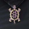 A vintage marine life brooch pin set featuring a purple and gold turtle design.
