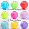 A collection of round paper lanterns in various shades of blue, green, pink, and yellow, showing different sizes.