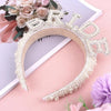 Un bandeau de mariée en cristaux de perle présenté sur un fond rose avec des accents floraux.