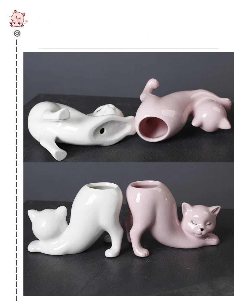 A pair of ceramic cartoon cat planters, one white and one pink, featuring a tail design.